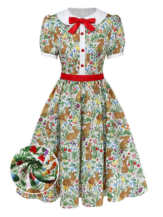 Ein kurzärmeliges A-Linien-Kleid im Vintage-Stil mit verspieltem Hasen- und Wildblumenmuster, weißem Peter-Pan-Kragen und roter Schleife als Akzent.