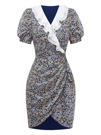 Studioaufnahme von vorne, die das geblümte Minikleid mit dem gewickelten Rockdetail und der dekorativen weißen Rüsche am Ausschnitt hervorhebt.