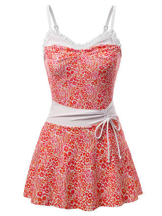 Ein roter, neonfarbener Leoparden-Badeanzug mit Rüschen im Stil der 1950er-Jahre und passendem Strandkleid – ideal für einen auffälligen Pool-Look oder einen Sommerurlaub im Resort.