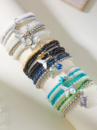 Set aus drei Perlenarmbändern mit Anhängern auf hellem Hintergrund