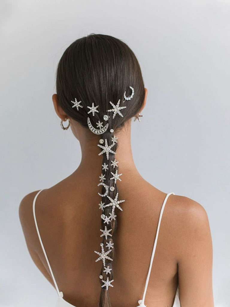 Frau mit aufwendig frisiertem Haar, verziert mit Seestern- und Mondmotiven auf schlichtem Hintergrund