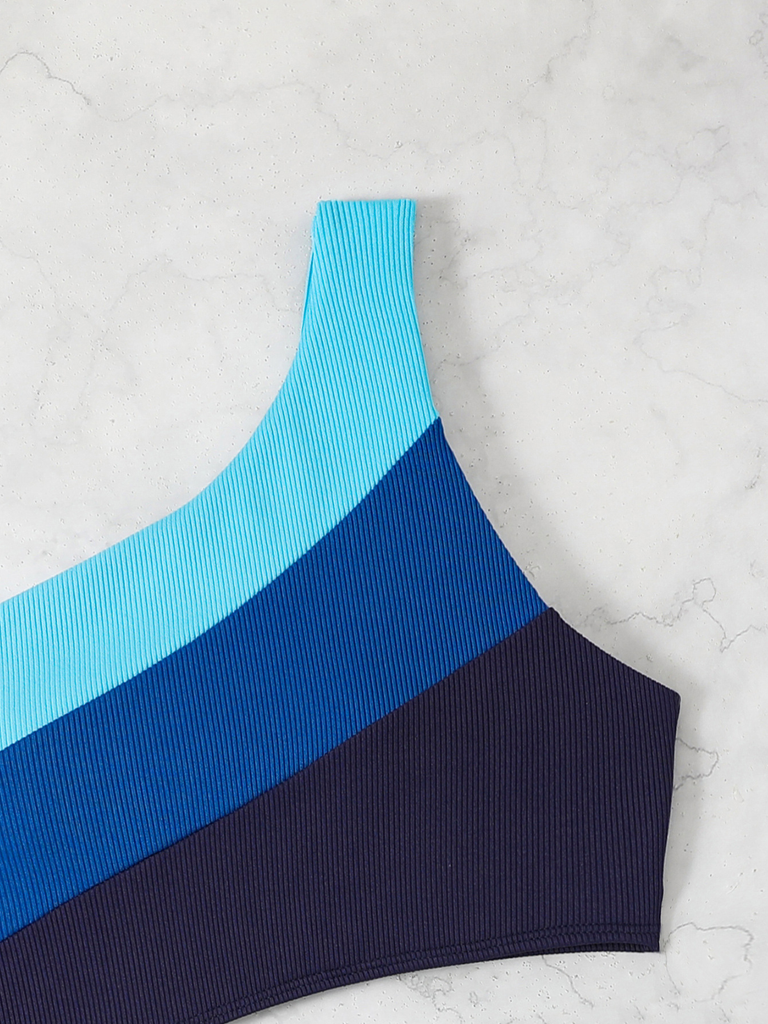Blau-schwarzes geripptes Crop-Top auf hellgrauem Hintergrund