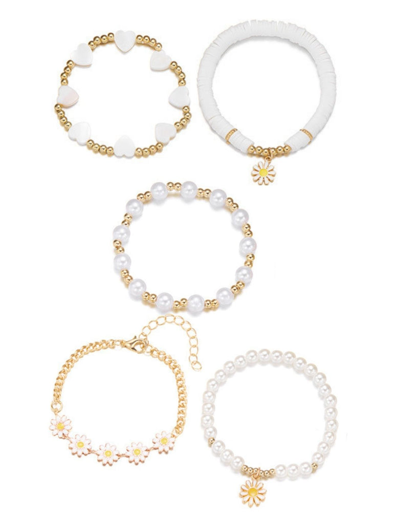 Ein Set aus stapelbaren Armbändern im Boho-Stil mit zarten Gänseblümchen-, Perlen- und Herzperlen, das sommerlichen Festival-Outfits oder lässiger Alltagskleidung eine verspielte Note verleiht.