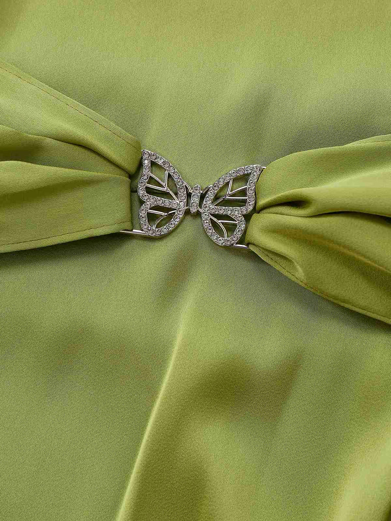 Grüner Stoff mit einer schmetterlingsförmigen Brosche