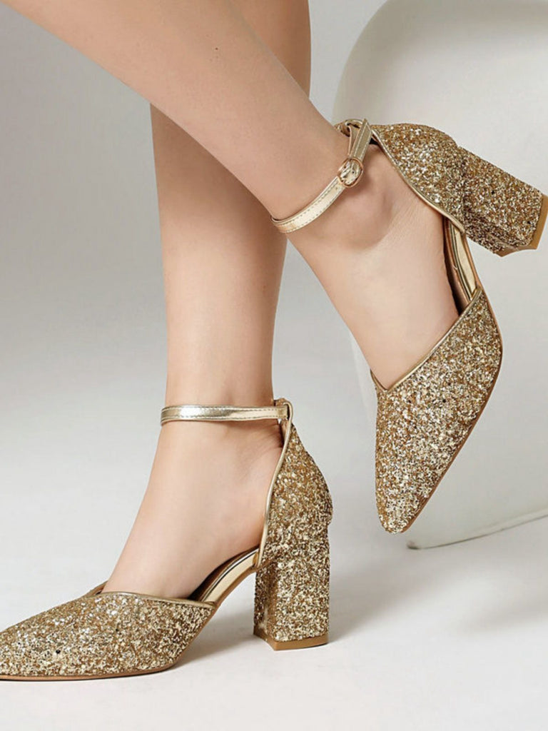 Goldglitzernde High Heels auf neutralem Hintergrund