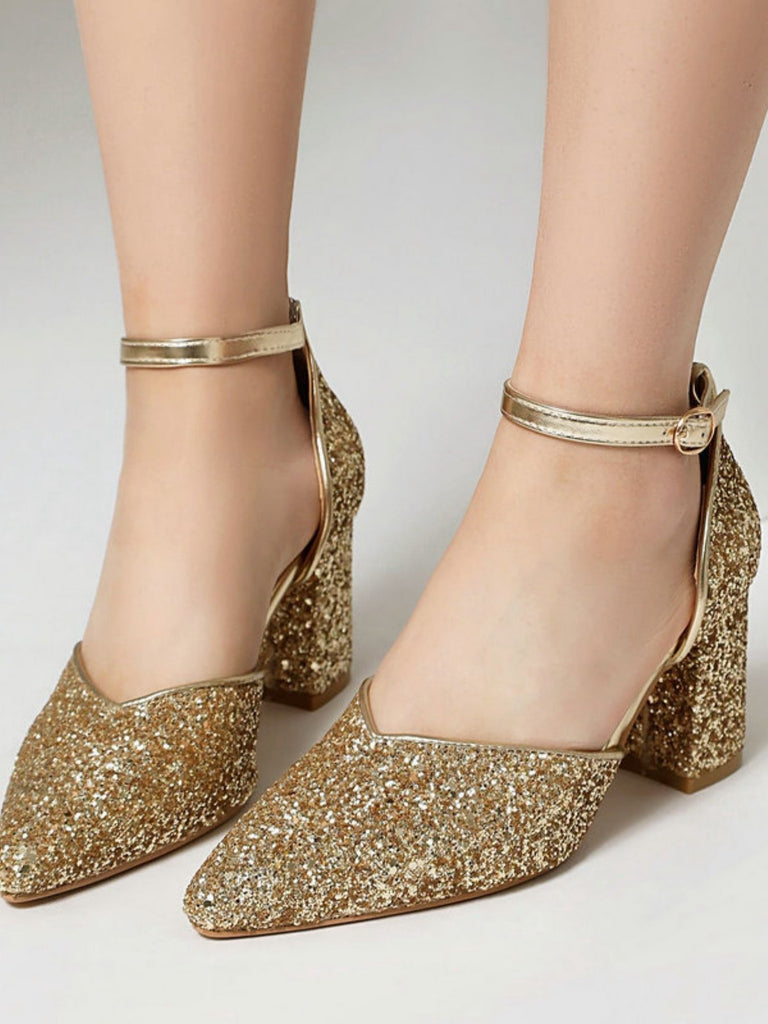 Goldglitzernde High Heels auf neutralem Hintergrund