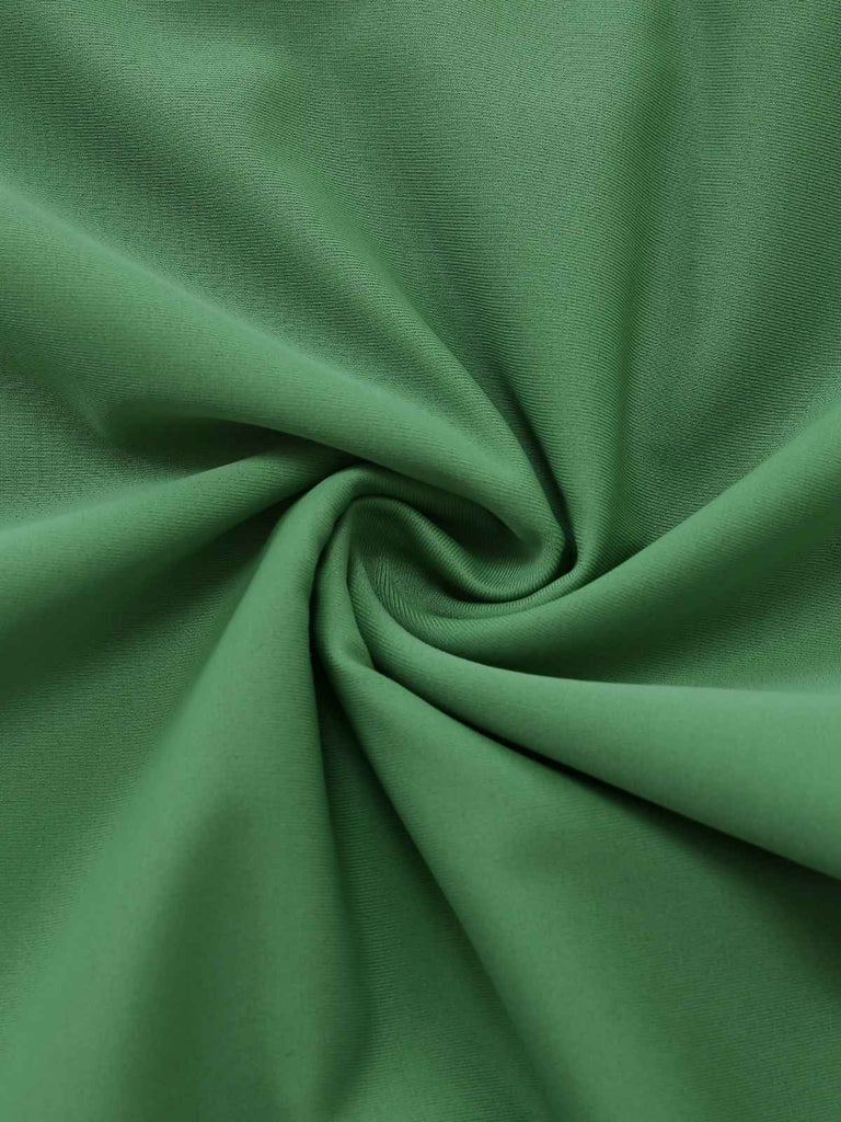 Detailaufnahme eines grünen Badeanzugstoffs im Vintage-Stil der 1950er Jahre mit Leopardenmuster. Die hochwertige Materialstruktur und das markante Tiermuster sind ein Muss für Liebhaber von Retro-Bademode.