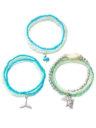 Drei Perlenarmbänder mit Anhängern auf weißem Hintergrund