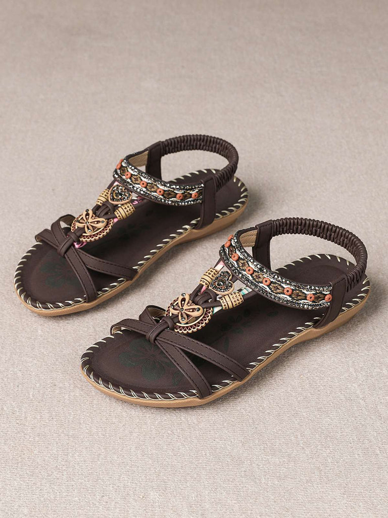 Flache Sandalen im Boho-Stil mit Perlenstickerei in Schmetterlings- und Herzform sowie Strassverzierungen – perfekt für gemütliche Sommerspaziergänge oder elegante Strandoutfits.