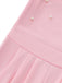 Nahaufnahme eines rosa Jumpsuits mit Perlenverzierungen auf weißem Hintergrund