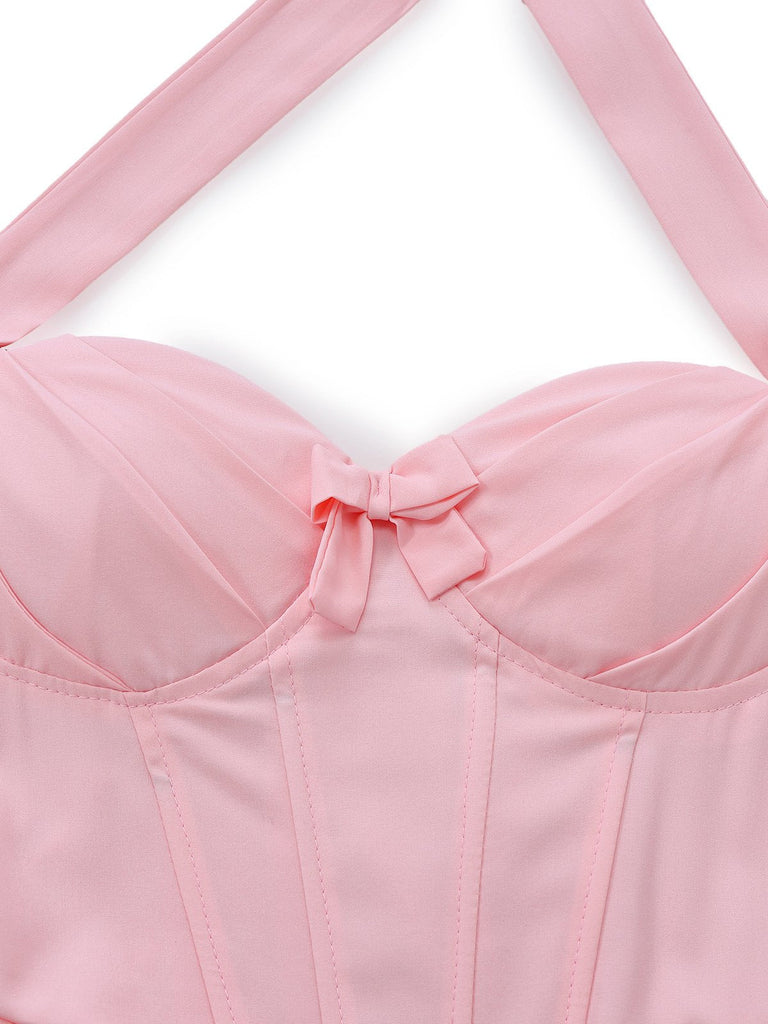 Nahaufnahme eines pinkfarbenen Bikini-Oberteils mit dünnen Trägern vor weißem Hintergrund