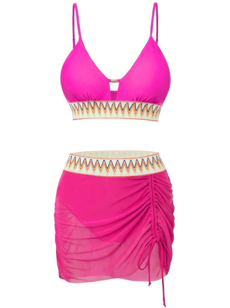 Pinkfarbenes Bikini-Set mit gerafftem Rock auf weißem Hintergrund