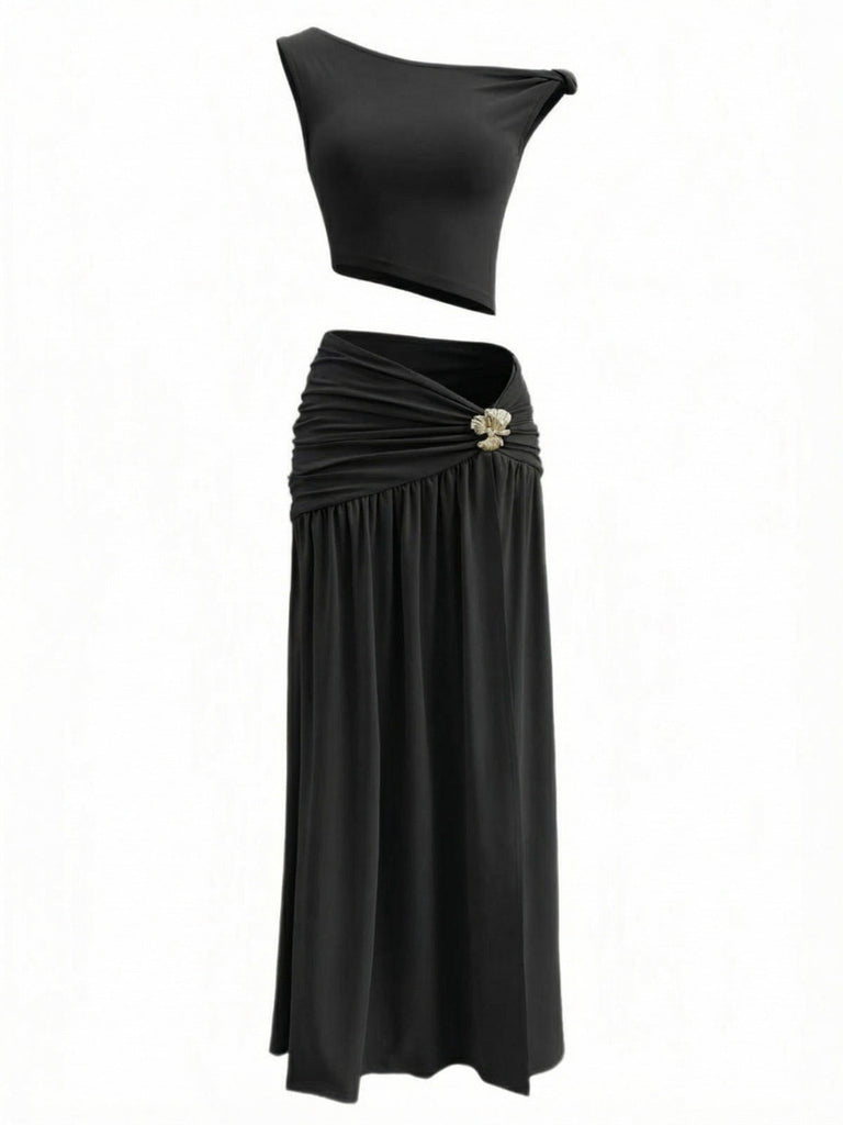 Schwarzes zweiteiliges Outfit mit Oberteil und Rock auf weißem Hintergrund