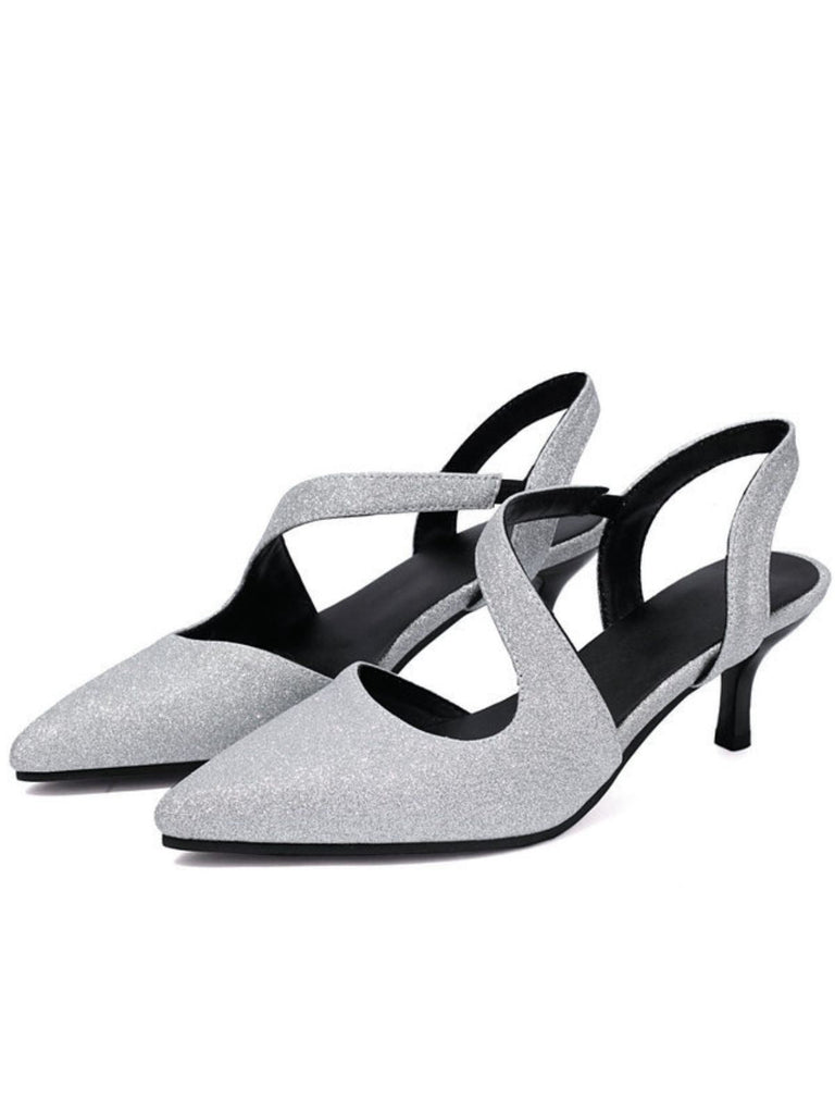 Ein Paar silberne, glitzernde Kitten-Heel-Schuhe auf weißem Hintergrund