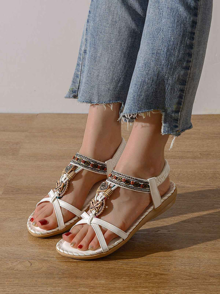 Flache Sandalen im Boho-Stil mit Perlenstickerei in Schmetterlings- und Herzform sowie Strassverzierungen – perfekt für gemütliche Sommerspaziergänge oder elegante Strandoutfits.