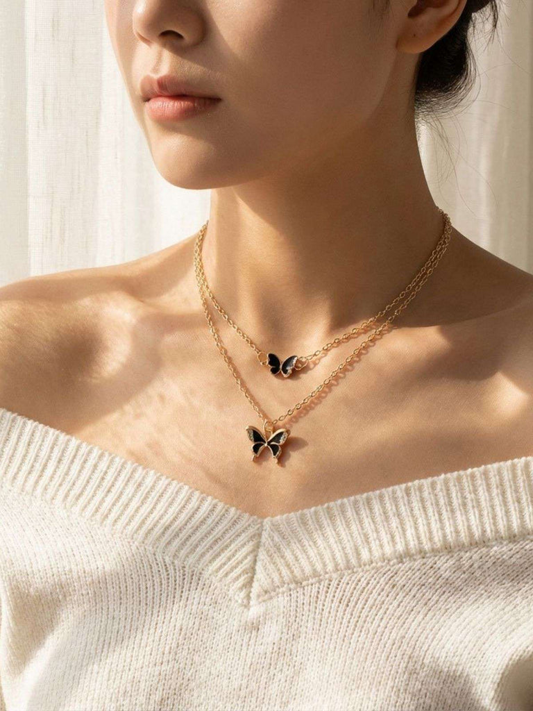 Nahaufnahme einer Person mit einer Schmetterlingskette vor sanftem Hintergrund