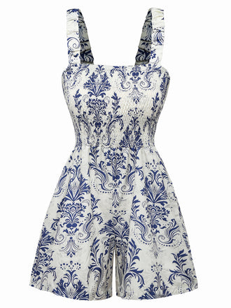 Vorderansicht des blau-weiß geblümten Jumpsuits, der den eckigen Ausschnitt und die ausgestellten Shorts zeigt.