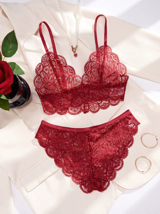 Das burgunderrote Dessous-Set aus Spitze, präsentiert auf einem weißen Satintuch mit einer Rose, eignet sich perfekt als romantisches Geschenk.