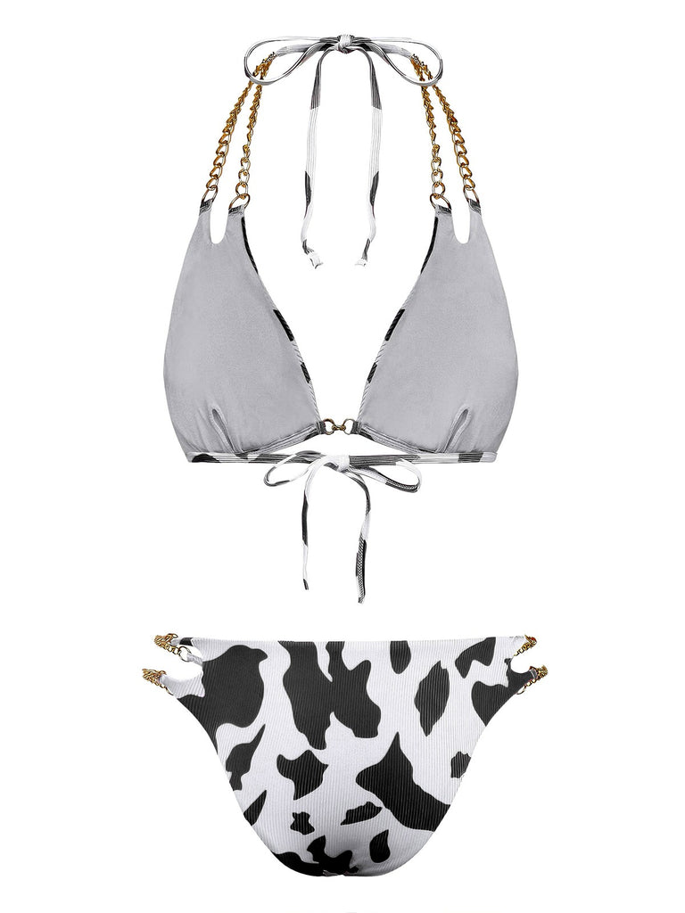 Rückansicht des schwarz-weißen Bikinis mit Kuhmuster, die die Bindebänder und die goldenen Kettenriemendetails zeigt.