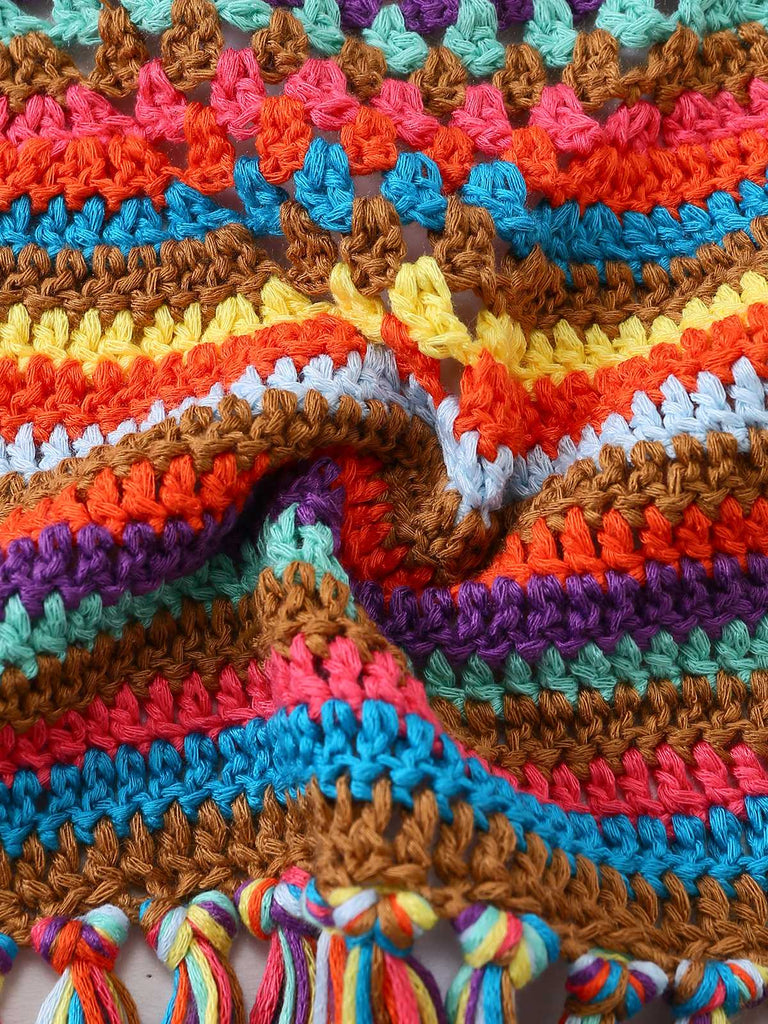 Makroaufnahme des gehäkelten Strickstoffs, die die verschiedenen farbigen Garne und die handgefertigte Textur hervorhebt.