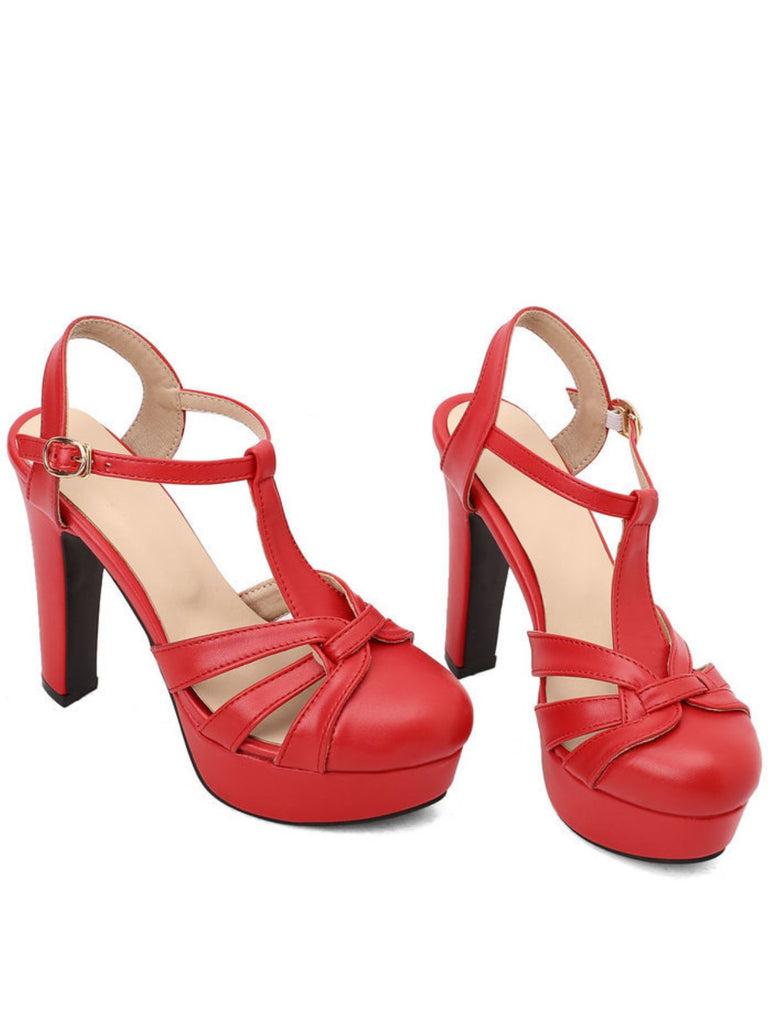 Ein Paar auffällige rote High-Heel-Sandalen mit klassischem T-Riemen und stabilem Plateau.