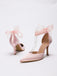 Ein Paar rosa High Heels mit Schleifen auf weißem Hintergrund