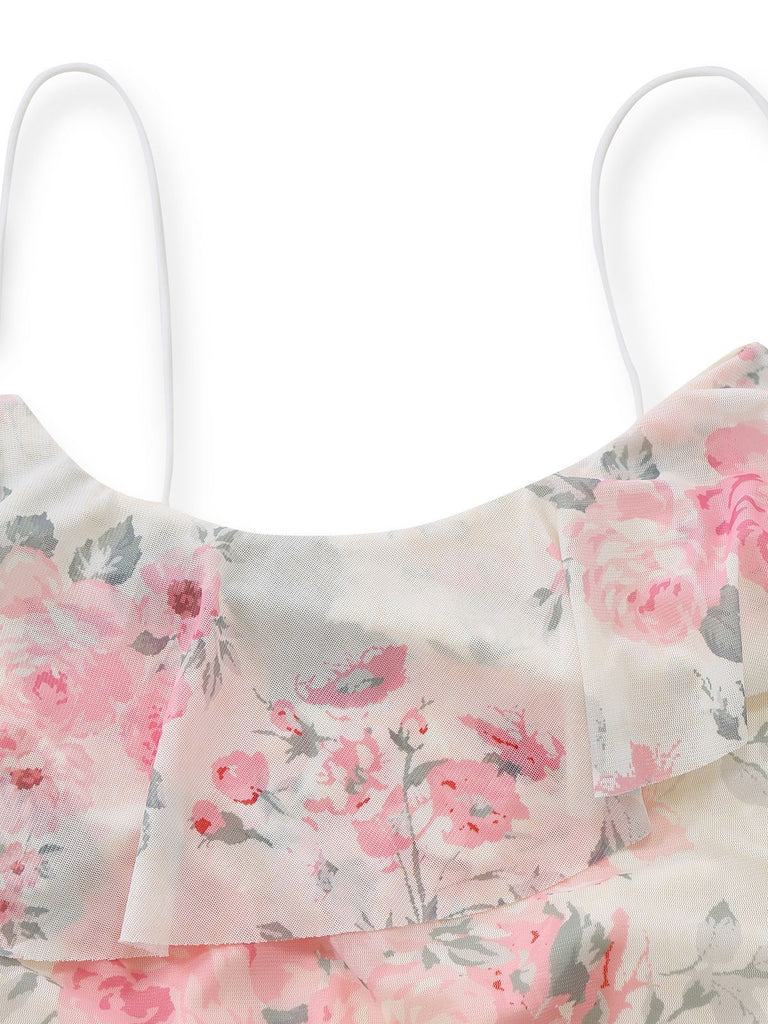 Nahaufnahme der zarten weißen Spaghettiträger und der mehrlagigen Rüschen am Ausschnitt des Kleides.