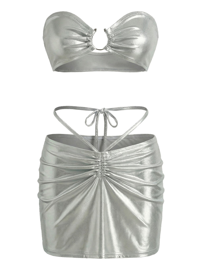 Ein zweiteiliges Set in Metallic-Silber, bestehend aus einem trägerlosen, gerafften Bandeau-Top mit einem Ringdetail in der Mitte und einem passenden hochtaillierten Minirock mit Raffungen vorne und Bindebändern.