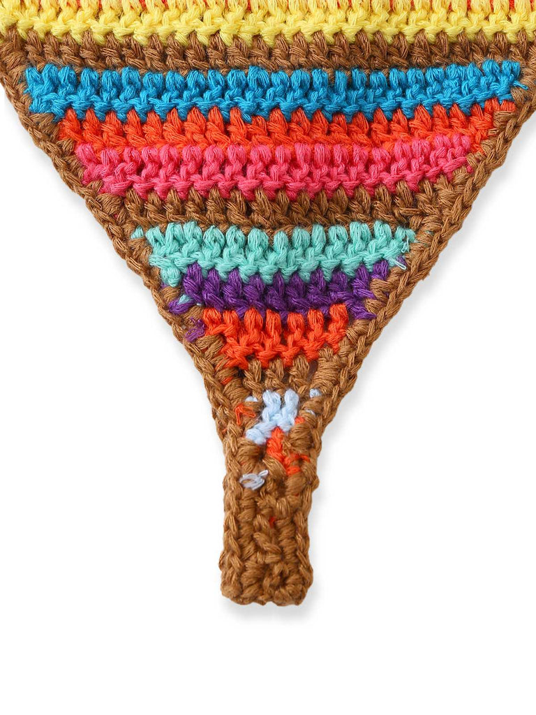 Nahaufnahme der Vorderseite des gehäkelten Bikinihöschens, die die horizontalen Streifen in Erdtönen und leuchtenden Farben zeigt.