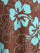 Makroaufnahme der Stoffdetails, die die türkisfarbenen Hibiskusblüten und die weißen Linienzeichnungen des Blattwerks auf schokoladenbraunem Hintergrund zeigt.