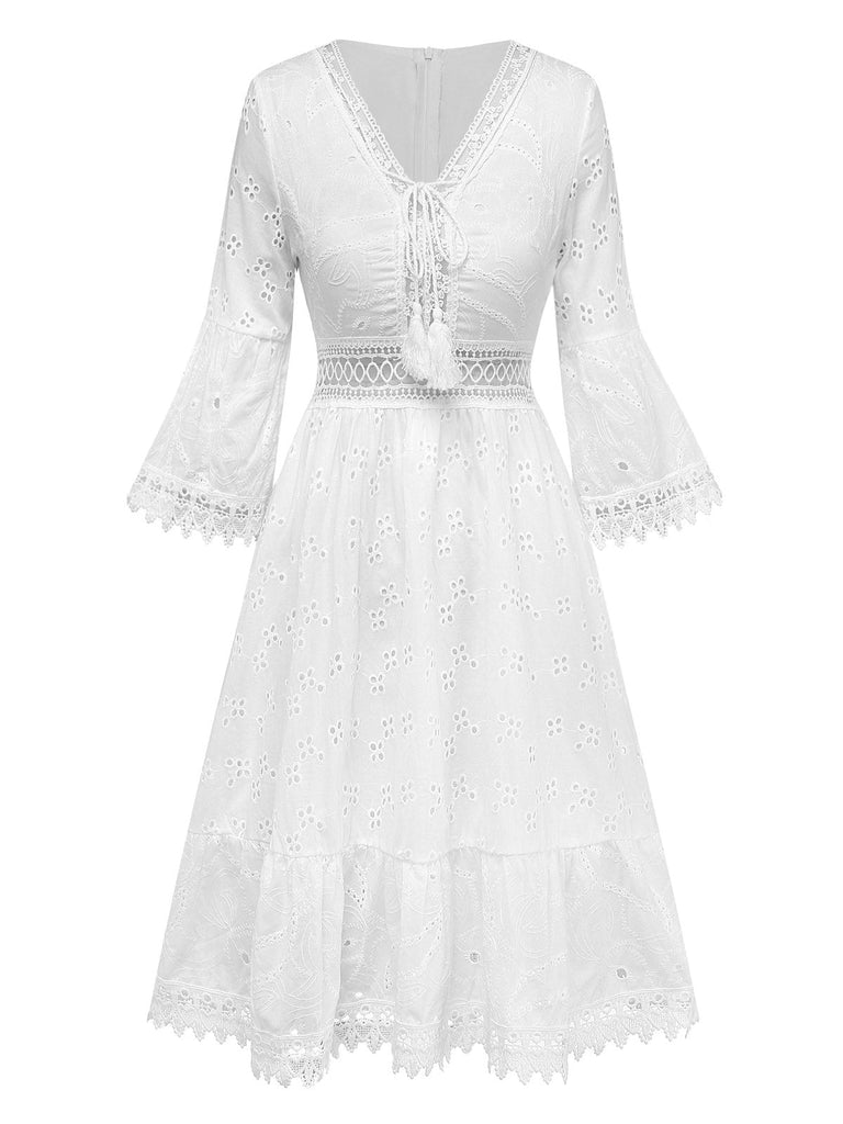 Weißes Spitzenkleid mit Glockenärmeln auf weißem Hintergrund