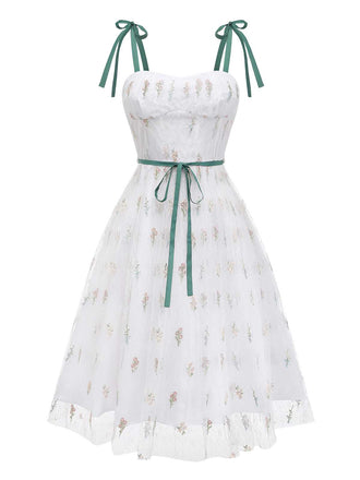 Studioansicht von vorn auf das weiße Netz-Kleid, das den herzförmigen Ausschnitt und den Stufenrock hervorhebt.